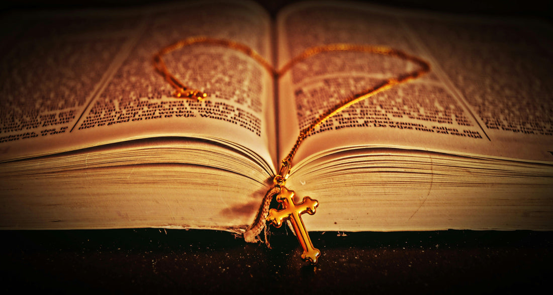 Gold-colored Cross Pendant on Bible by George Becker